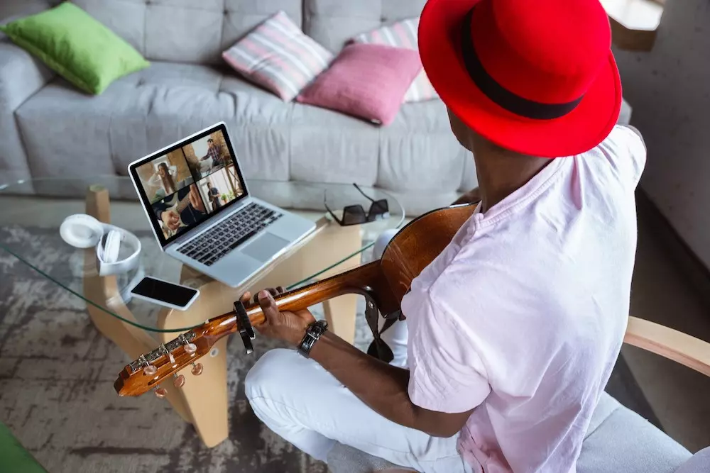 musician playing guitar during online meeting