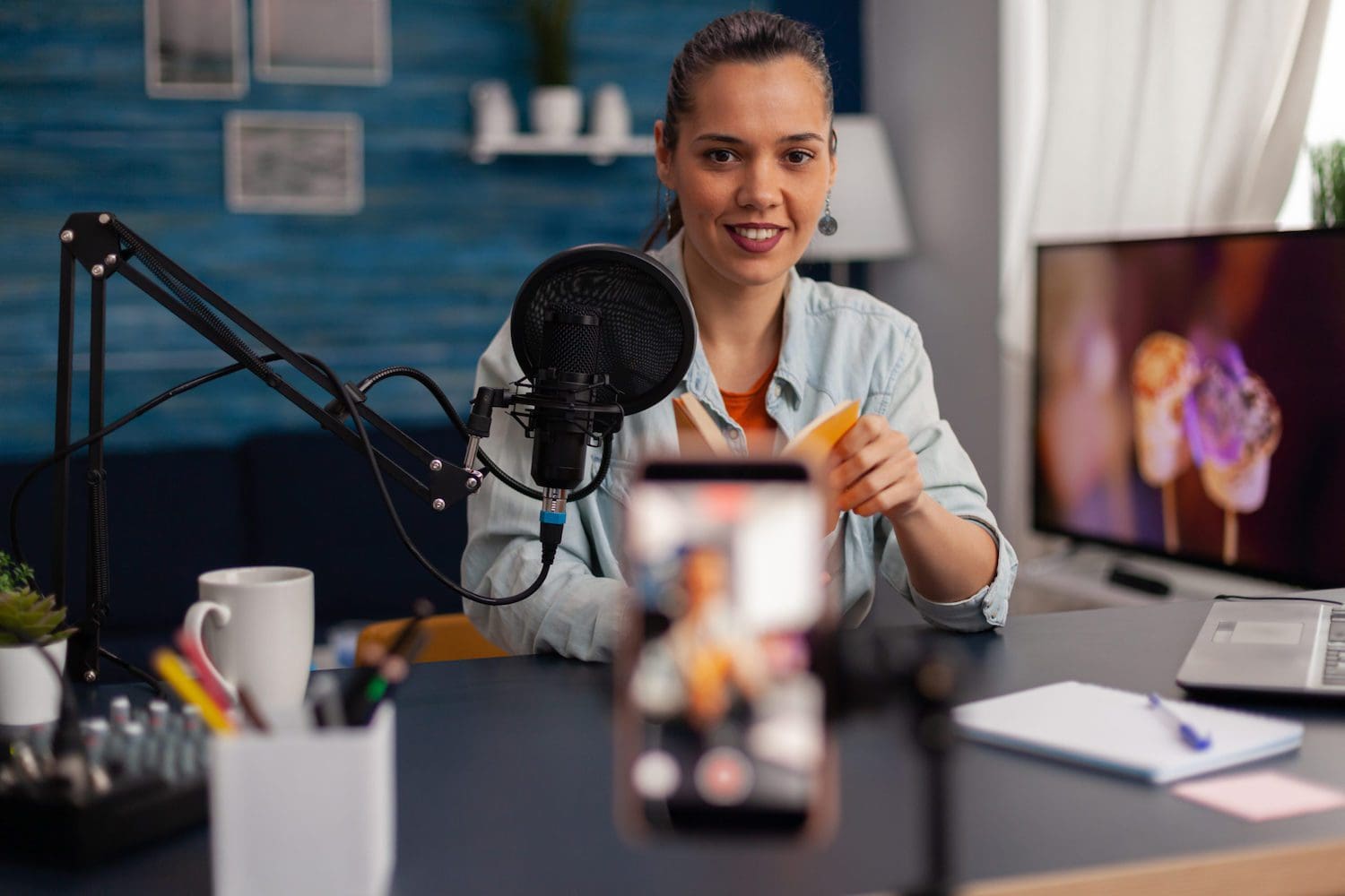 woman recording video with phone and studio microphone