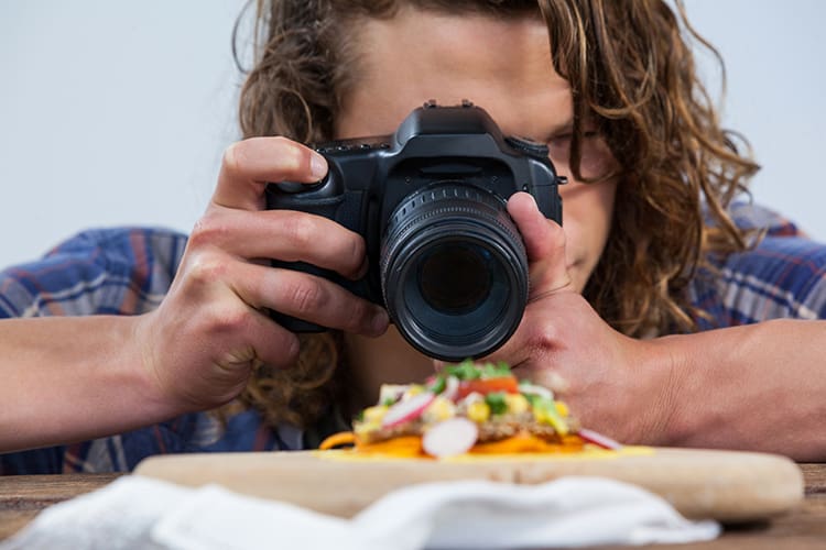 Close-up of photographer clicking a picture of food using digital camera